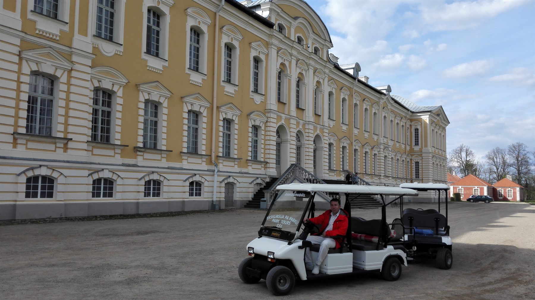 Elektromobilis ar viesiem Rundāles pils parkā.