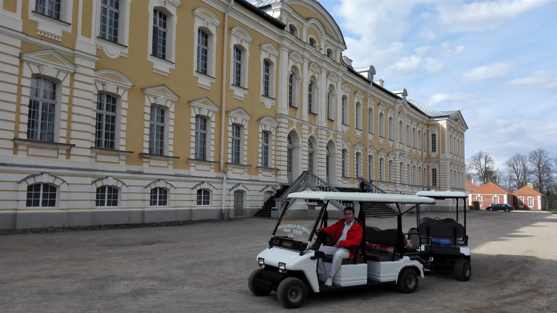 Elektromobilis ar viesiem Rundāles pils parkā.